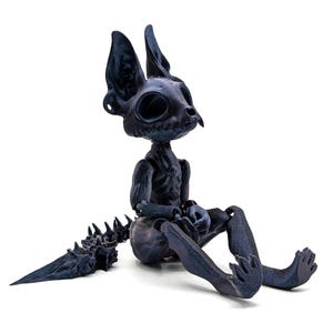 May include: A black skeletal cat figurine with a long, spiky tail. The figurine is made of a dark, textured material and has a detailed skeletal structure.