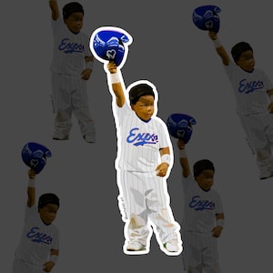 Puede incluir: Una pegatina con un joven jugador de béisbol con un uniforme de rayas blancas y azules, levantando un casco azul. La palabra "Expos" está escrita en azul en la camiseta. La pegatina tiene un fondo gris.