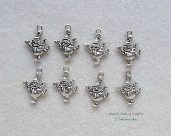 May include: Eight silver-toned metal charms featuring a snowman ice skating. The charms are perfect for adding a festive touch to jewelry making projects.