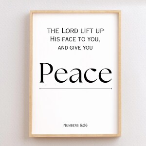 May include: A framed print with a white background and black text. The text reads "THE LORD LIFT UP HIS FACE TO YOU, AND GIVE YOU Peace NUMBERS 6:26".