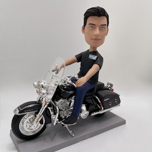 Könnte beinhalten: Eine schwarze und silberne Motorradfigur mit einem Mann darauf. Der Mann trägt ein schwarzes T-Shirt mit dem Wort "SAP" und eine blaue Jeans. Das Motorrad hat eine Windschutzscheibe und einen Seitenwagen.