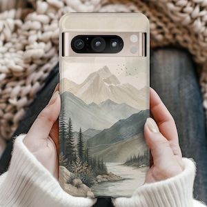 K&ouml;nnte beinhalten: Eine Smartphone-H&uuml;lle mit einer Landschaftsillustration von schneebedeckten Bergen, einem gewundenen Fluss und einem dichten Kiefernwald in gedeckten Beige-, Salbeigr&uuml;n- und Graut&ouml;nen. Das Design zeigt zudem einen kleinen Vogelschwarm am Himmel.