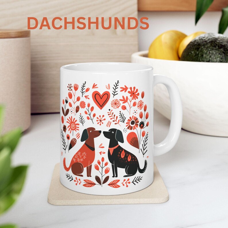 May include: White coffee mug with a red heart and two dachshund dogs kissing in a floral pattern. The text 'Dachshunds' is printed in red at the top of the mug.
