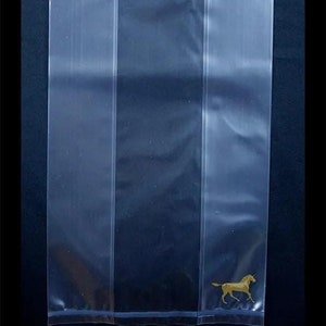 May include: A clear plastic bag with a small white square window and a gold horse silhouette at the bottom.