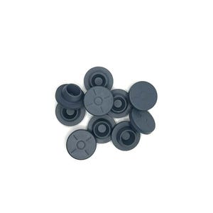 Könnte beinhalten: Eine Gruppe von zehn schwarzen Gummistopfen für Flaschen mit einem kreuzförmigen Design in der Mitte.