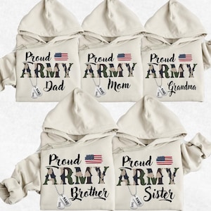 May include: Five beige hooded sweatshirts with a camouflage pattern and the words "Proud Army" printed on them. Each sweatshirt has a different word below the text, including "Dad", "Mom", "Grandma", "Brother", and "Sister".