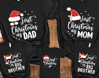 May include: A set of five black t-shirts with white text and a red Santa hat graphic. The shirts say "First Christmas as Dad", "First Christmas as Mom", "First Christmas as Big Brother", "First Christmas as Big Brother", and "My First Christmas".