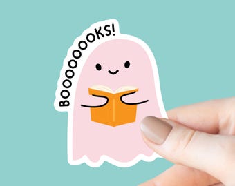 May include: A pink ghost holding an orange book with the text "BOO-OOOOKS!" above it.
