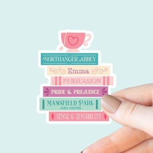 May include: A sticker featuring a stack of books with titles like "Northanger Abbey," "Emma," and "Pride & Prejudice." A pink teacup with a heart detail sits atop the books. The sticker has a light blue background.