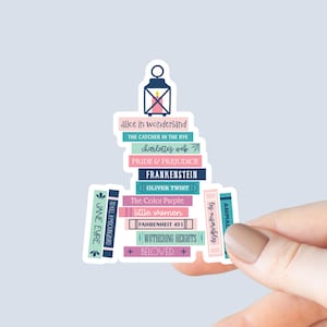 May include: A sticker of a stack of books with the titles of popular novels, including "Alice in Wonderland", "The Catcher in the Rye", "Charlotte's Web", "Pride & Prejudice", "Frankenstein", "Oliver Twist", "The Color Purple", "Little Women", "Fahrenheit 451", "Wuthering Heights", "Beloved", "Jane Eyre", "To Kill a Mockingbird", "Animal Farm", and "Les Miserables".