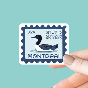 May include: A sticker in the shape of a postage stamp featuring a cartoon illustration of a loon. The stamp has the text "STUPID CANADIAN WOLF BIRD" and "MONTREAL". The stamp is blue with a white border and a light blue background.