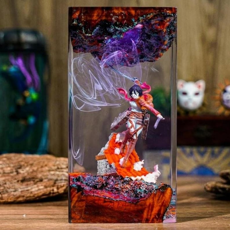Puede incluir: Una escultura rectangular de resina con una figura de un personaje con una espada, sobre un fondo de efectos morados y blancos. La base es una mezcla de madera y resina, con resina transparente.