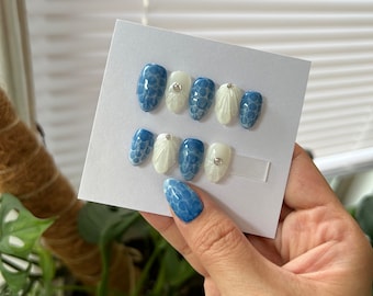 May include: Set of blue and white press-on nails with a marble design and rhinestones.