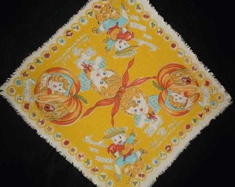 Może przedstawiać: Kwadratowa żółta chusteczka z materiału z frędzlami na brzegach, ozdobiona ilustracjami dzieci, dyń oraz napisem Tom, Tom, the piper's son i The little girl had a little curl. Wzór zawiera małe motywy kwiatowe wzdłuż krawędzi.
