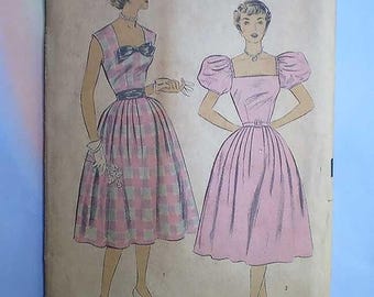 Może przedstawiać: Koperta z wykrojem krawieckim w stylu vintage z ilustracjami dwóch sukienek. Lewa sukienka w różowo-szarą kratę z kokardą przy dekolcie. Prawa sukienka w kolorze różowym z bufiastymi rękawami. Tekst: SIZE 12, BUST 30, HIP 33.