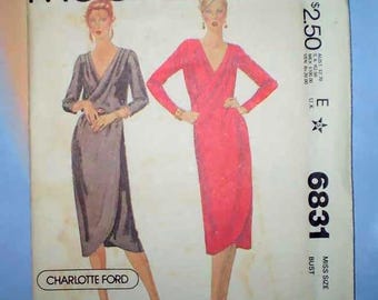 May include: A vintage McCall's sewing pattern envelope, number 6831, featuring illustrations of two wrap-style dresses with long sleeves and V-necklines. One dress is depicted in a dark grey tone, and the other is in a bright pink shade. The text includes Charlotte Ford, McCall's, and size information.