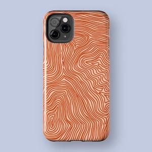 May include: A phone case with a topographic map design. The case features a pattern of orange lines on a beige background. The case has a black camera module and a glossy finish.