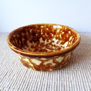 May include: A white ceramic mug with a black handle and the text "But First, Coffee" in a black, bold font. The mug is on a white surface.