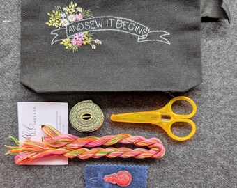 Naaipakket. Geborduurde portemonnee met bloemen, gebladerte en banner.