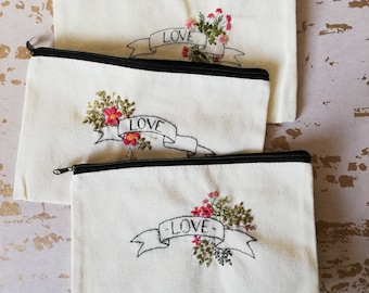 Portemonnee met bloemen- en gebladerte borduurwerk en liefdesbanner, make-upetui, etui