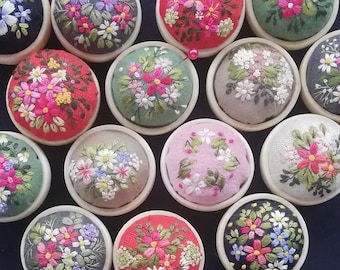 Geborduurd bloemenspeldenkussen in een houten pot