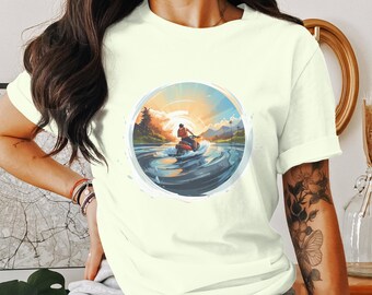 Puede incluir: Una camiseta blanca con un gráfico de una persona montando una moto acuática en un lago con una puesta de sol en el fondo.