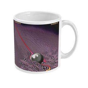 May include: White ceramic mug featuring a graphic of a black and white swirling pattern with a red and yellow line and a black sphere. The text "TAME IMPALA" and "CURRENTS" is printed on the mug.