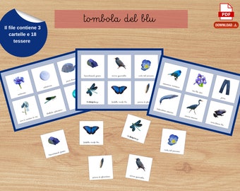 Könnte beinhalten: Ein Spielset mit dem Titel "tombola del blu" mit drei Spielbrettern und 18 Karten. Die Bretter und Karten zeigen Illustrationen von blauen Objekten, darunter Blumen, Insekten und Tiere. Das Set liegt auf einer Holzoberfläche.