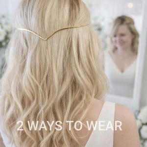 Puede incluir: Una mujer con cabello rubio ondulado lleva un accesorio para el cabello de color dorado. El texto "2 WAYS TO WEAR" se muestra en la parte inferior de la imagen. Un espejo refleja la cara y la parte superior del cuerpo de la mujer.