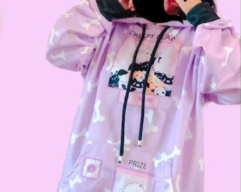 May include: A light purple hoodie with a bone pattern and black accents. The hoodie features a front pocket with a cartoon ghost and the word "PRIZE". The hood has black drawstrings and the text "CREEPY CLAW".