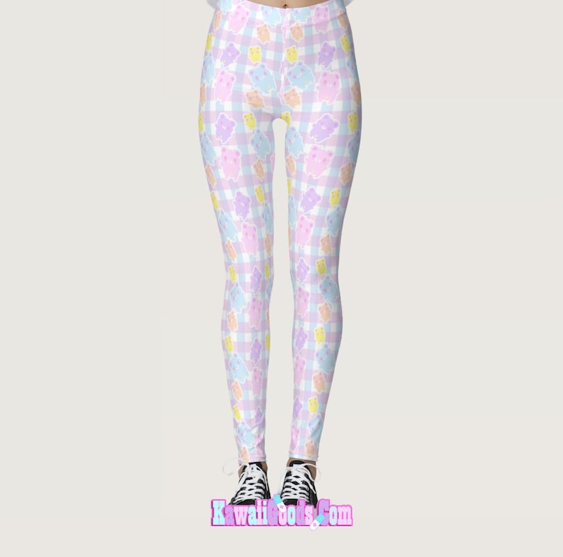 May include: Pink, blue and yellow leggings with a gingham pattern and cartoon bears. The leggings are on a white background.