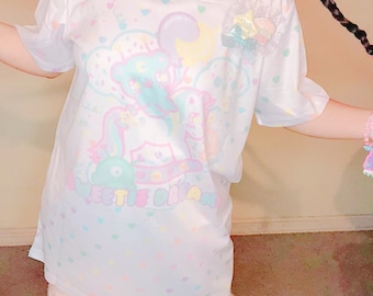May include: White t-shirt with a pastel illustration of a bear, moon, and clouds, with the text "Sweetie Dream". The shirt is paired with pastel shorts and leggings, creating a whimsical, dreamy aesthetic.