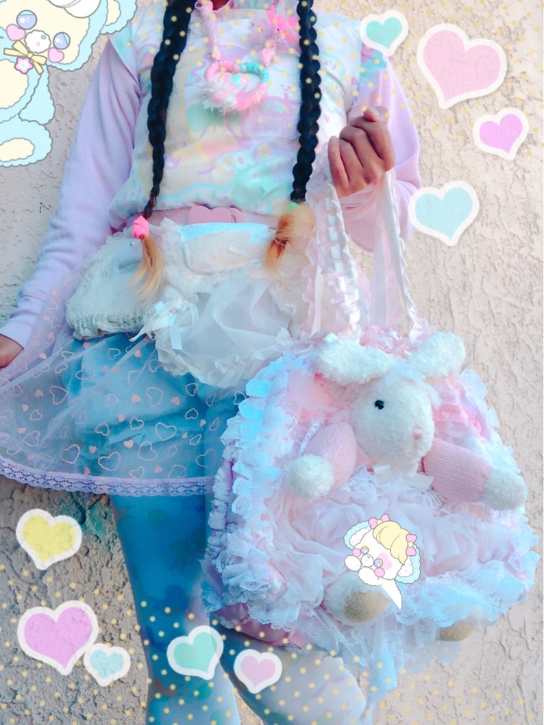 May include: A pastel-toned outfit with a light pink top, a skirt with heart motifs, and blue leggings. A large pink and white plush bunny bag with lace trim is held. The outfit has a whimsical, kawaii aesthetic, with a focus on soft colours.