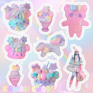 May include: A set of colorful, whimsical stickers featuring a unicorn, a bear, a cupcake, and a character with a rainbow-colored head. The stickers are decorated with glitter, stars, and other cute details. The text "Kawaii Goods" is visible at the bottom of the image.