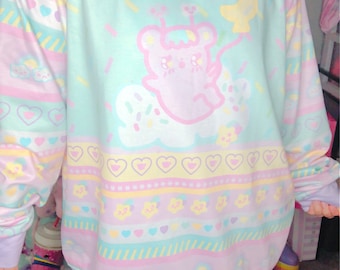 May include: Pastel-colored sweatshirt with a repeating pattern of hearts, stars, and clouds. The design features a cartoon bear holding a moon-shaped balloon. The text "KAWAII GOODS" is at the bottom of the sweatshirt.