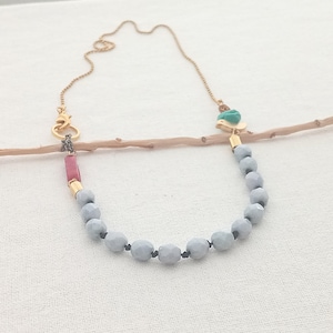 Vogeltje dat vrolijk zingt. Chokerketting. Geknoopte lichtblauwe facetkralen