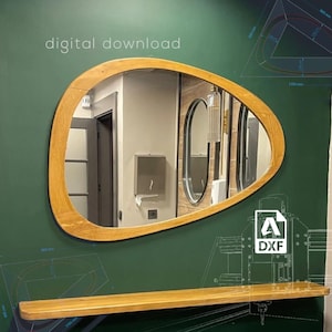 Puede incluir: Una descarga digital para un espejo ovalado de madera con un borde biselado. El espejo está montado en una pared verde con un estante de madera debajo. El texto "descarga digital" está escrito en blanco en la pared. La imagen también incluye un dibujo de estilo plano del espejo y el estante.