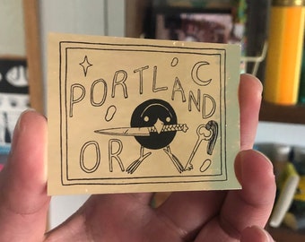 Portland, Oregon Bird with Knife Black on Gold Foil Sticker by Deth P. Sun