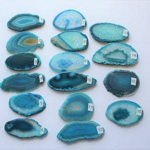 May include: Sixteen agate slices in various shades of blue and green. The slices are arranged in four rows of four, with each slice numbered from 1 to 16.