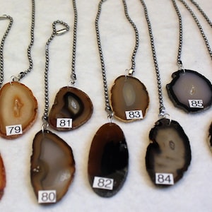 May include: Ten agate slices on chains, each with a unique pattern and color, numbered 77 through 87. These agate slices are perfect for adding a touch of natural beauty to your home decor.