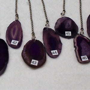 May include: Nineteen purple agate pendant light pull chains with silver chains. The agate is in various shapes and sizes. Each pendant is numbered 38 through 49.