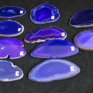 May include: Ten purple agate slices with natural patterns and white edges. The slices are numbered 1 through 10.