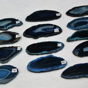 May include: Twelve agate slices in various shades of blue, each with a unique pattern and numbered 76 through 87.