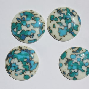 Puede incluir: Cuatro azulejos de cerámica redondos con fondo blanco y un patrón abstracto azul y verde.