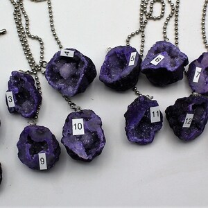May include: Fourteen amethyst crystal pendants on silver chains. Each pendant is numbered 1 through 14.