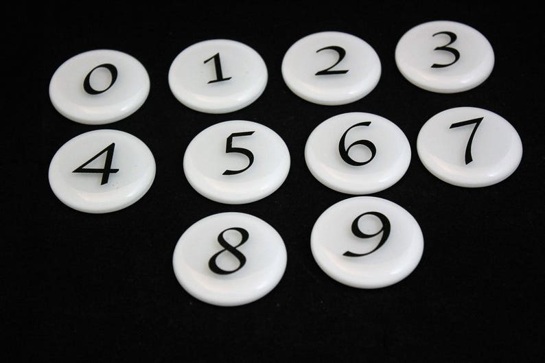 Puede incluir: Diez fichas redondas blancas con n&uacute;meros negros del 0 al 9.