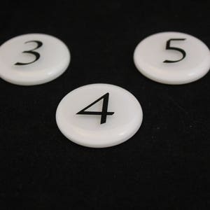 Puede incluir: Tres discos redondos blancos con los n&uacute;meros negros 3, 4 y 5 impresos en ellos.
