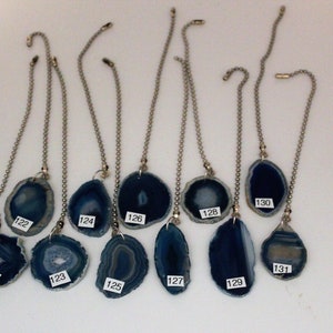 May include: Twelve agate pendant pulls with silver chains. The agate is blue and white with a layered pattern. The pendants are numbered 121 through 131.