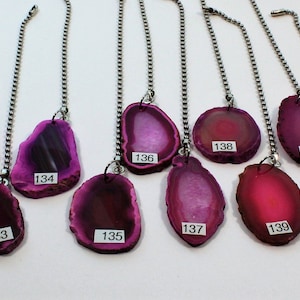 May include: A collection of 12 purple agate slices with silver chains, each slice has a number from 129 to 144.
