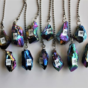 May include: Twelve iridescent crystal pendants on silver chains. Each pendant is numbered 25 through 36.